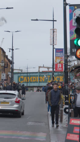 Vídeo-Vertical-De-La-Vista-A-Lo-Largo-De-Camden-High-Street-Ocupada-Con-Gente-Y-Tráfico-En-El-Norte-De-Londres,-Reino-Unido